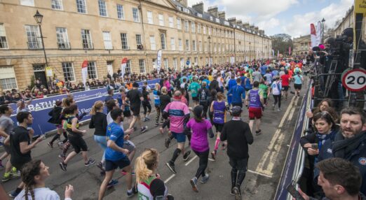Photograph of a crowd of runners in a race, running in the opposite direction from the camera
