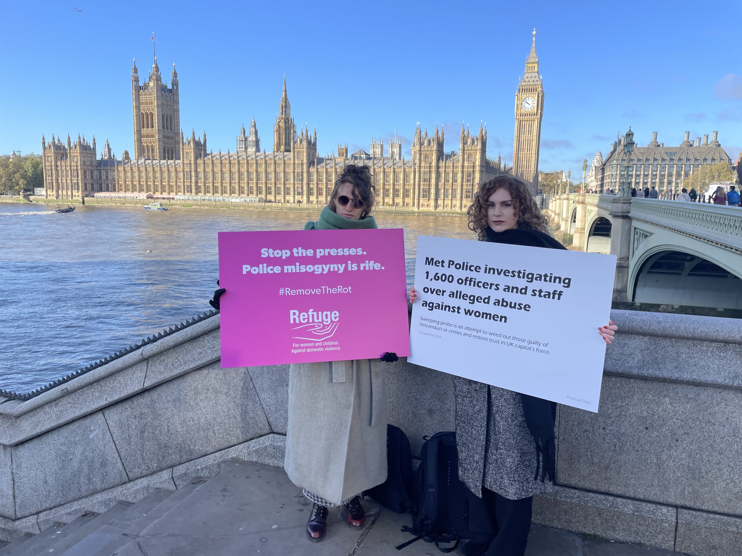 Image of two staff outside parliament with placards.