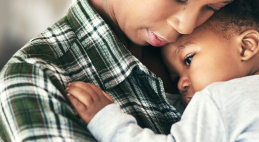 Close up image of a mother cradling her baby boy