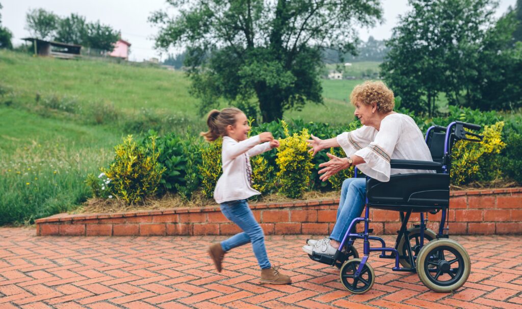 Granddaughter runs to meet her grandmother in a wheelchair