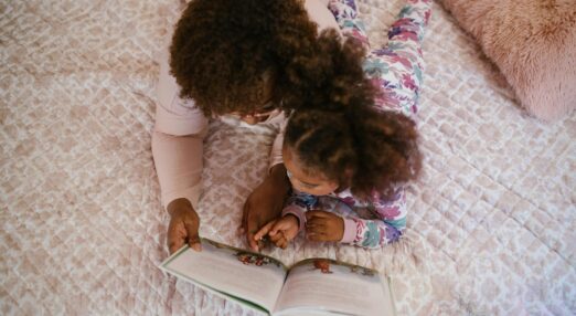 Mother reading a story to her daughter in bed