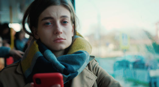 Image of a young girl on a bus looking directly at the camera