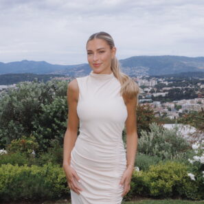 Zara McDermott smiling to camera in white dress