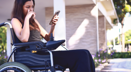 Woman in a wheelchair looks at phone