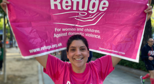 Woman wearing a Refuge T-shirt holding a Refuge flag above her head